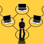 Illustration of a manager at the base of a network of laptops connected in a hierarchy, symbolizing oversight of a digital workforce of AI agents