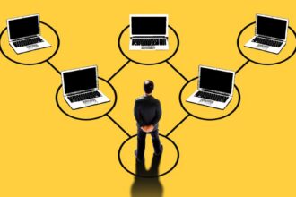 Illustration of a manager at the base of a network of laptops connected in a hierarchy, symbolizing oversight of a digital workforce of AI agents