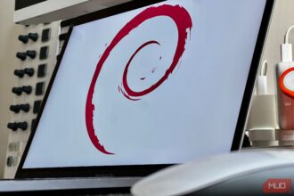 Debian logo on a laptop keyboard with code on screen