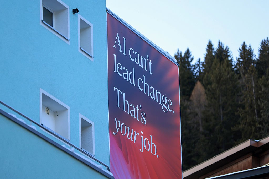 Red billboard reading AI can't lead change. That's your job in a mountain town