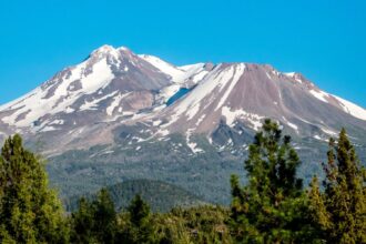 A mountain hiker silhouette against snow-capped peaks representing outdoor AI planning