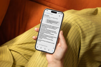 Phone showing a suspicious text message next to a laptop with an Amazon email open