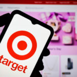 Shopper using the Target app photo search feature on a phone in a store aisle