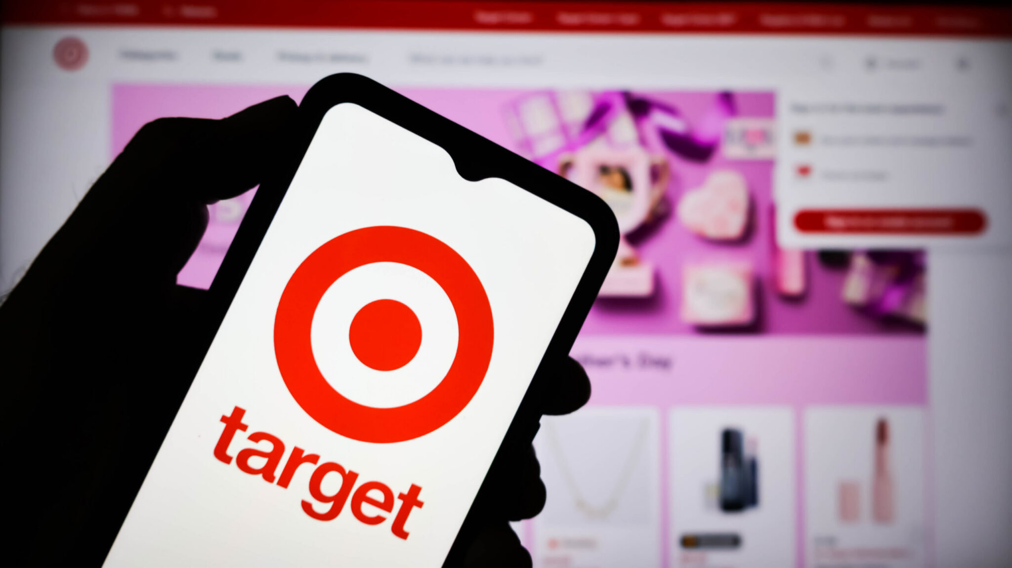 Shopper using the Target app photo search feature on a phone in a store aisle