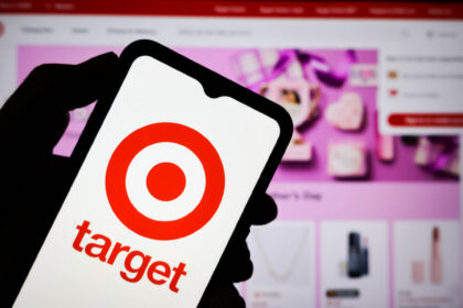 Shopper using the Target app photo search feature on a phone in a store aisle