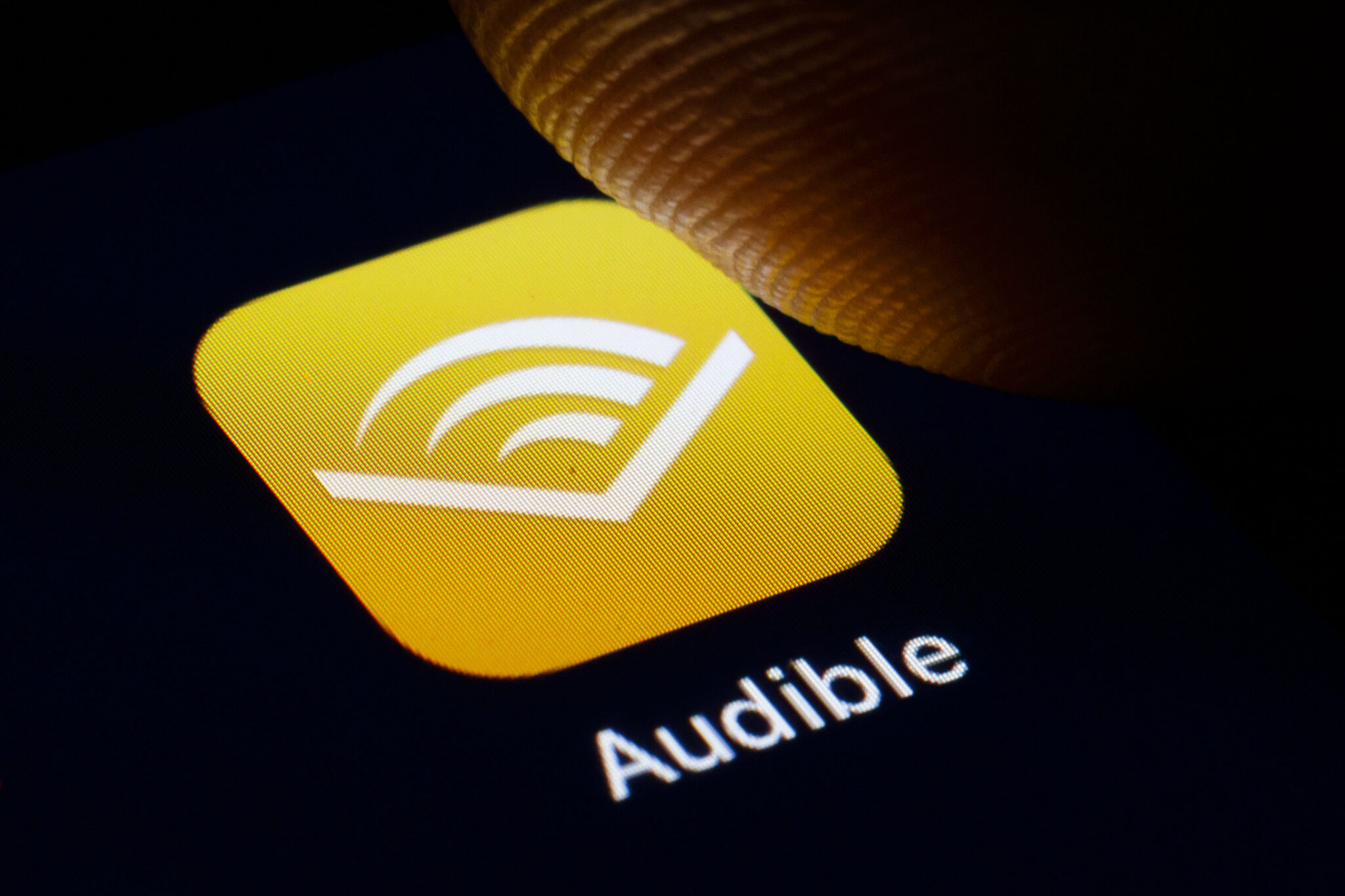 Person listening to an audiobook with headphones on a couch