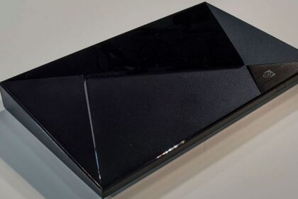 Nvidia Shield TV streaming box sitting next to a television remote