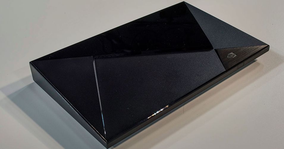 Nvidia Shield TV streaming box sitting next to a television remote