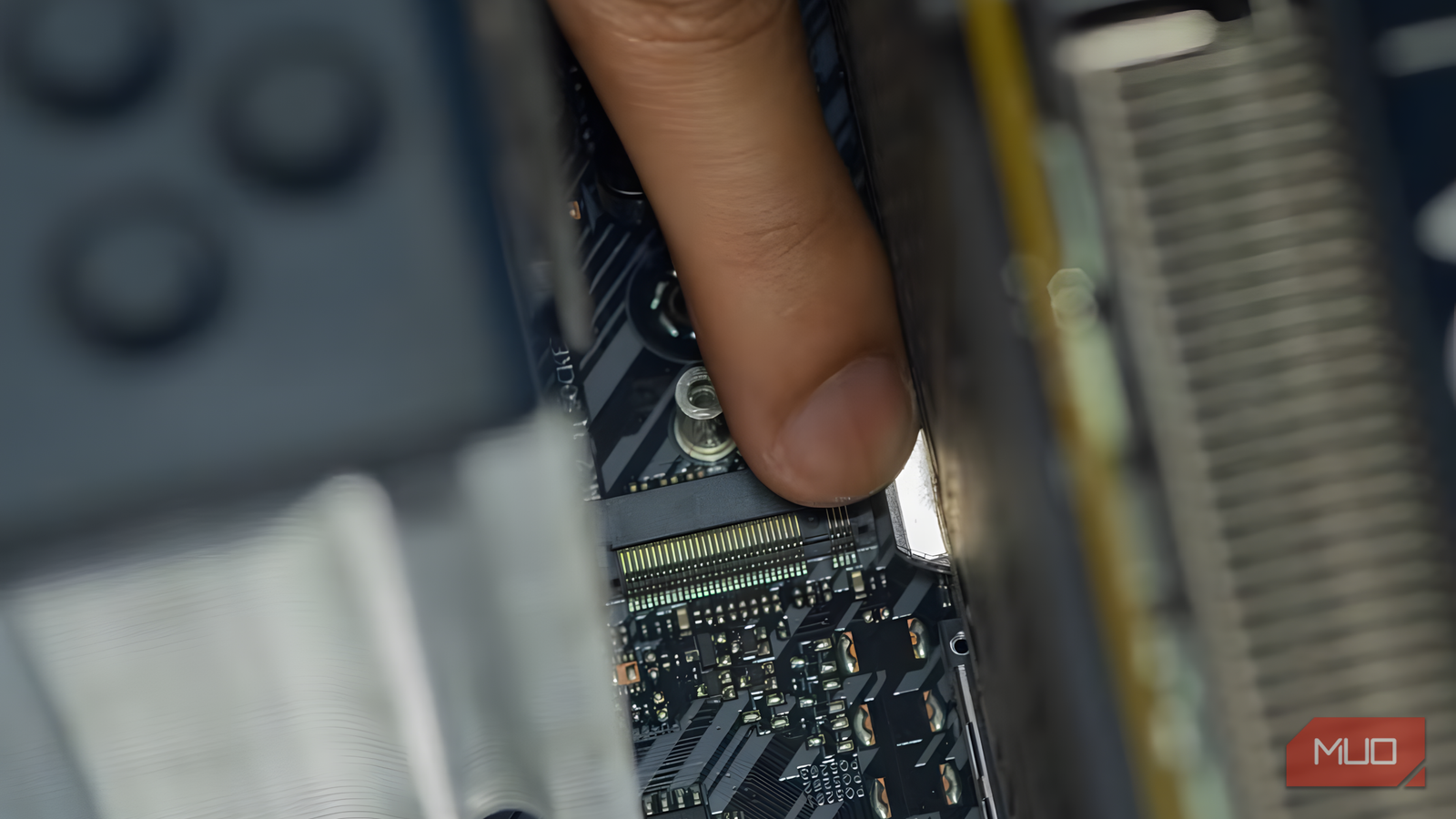 A hand unlatching a PCIe retention clip on a graphics card slot inside a desktop PC